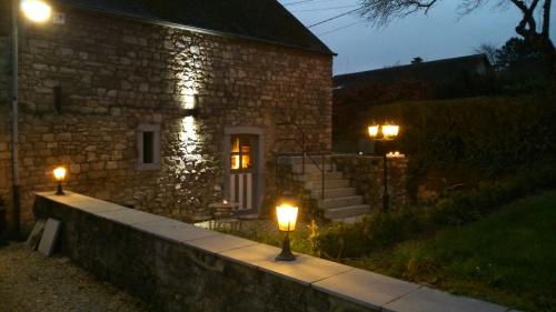 une maison en pierre avec deux lumières devant elle dans l'établissement Le Gîte Du Prieuré, à Namur