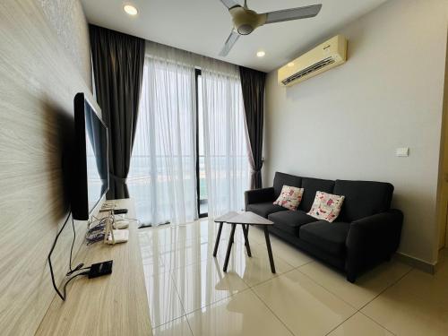 a living room with a black couch and a television at D'Pristine Medini, Iskandar Puteri Johor Bahru Walk to Legoland & Gleneagles in Iskandar Puteri
