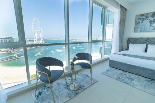 a bedroom with a bed and two chairs and a table at Al Bateen Resdences by HAPPY SEASON JBR in Dubai