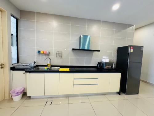 a kitchen with a black refrigerator and white cabinets at D'Pristine Medini, Iskandar Puteri Johor Bahru Walk to Legoland & Gleneagles in Iskandar Puteri