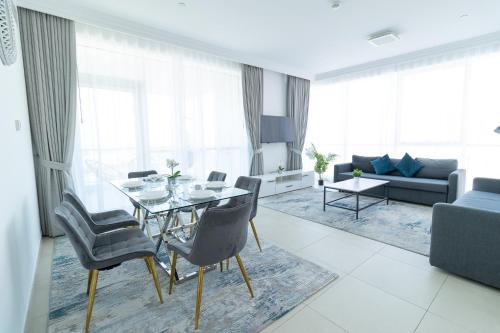 a living room with a table and chairs and a couch at Al Bateen Resdences by HAPPY SEASON JBR in Dubai