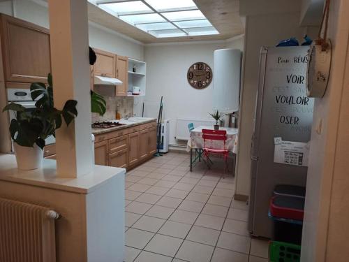 une cuisine avec un réfrigérateur et une table à l'intérieur dans l'établissement Petite Maison proche de la plage, à Grand-Fort-Philippe