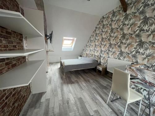 Cette petite chambre comprend un lit et une chaise. dans l'établissement Petite Maison proche de la plage, à Grand-Fort-Philippe