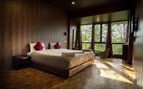 a bedroom with a large bed with red pillows at The Barfung Retreat in Gangtok