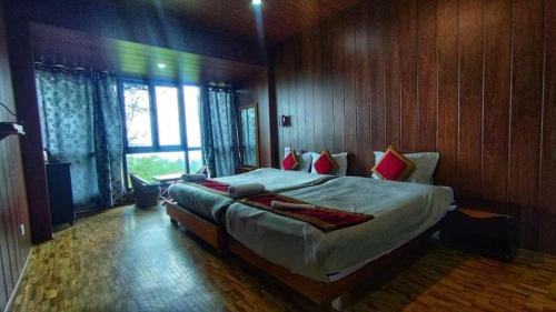 a bedroom with a large bed in a wooden room at The Barfung Retreat in Gangtok
