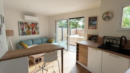 une cuisine et un salon avec un canapé et une table dans l'établissement La Brise des Bois pour 2 personnes, à Andernos-les-Bains