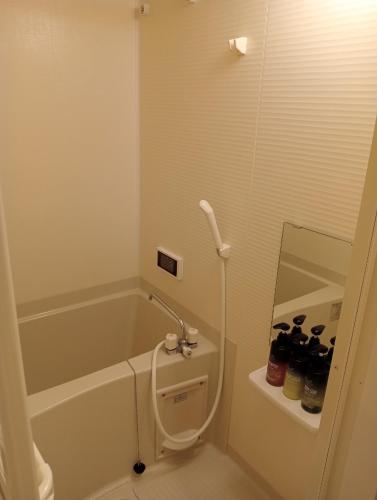 a bathroom with a tub and a toilet and a sink at HIZ HOTEL Gion-Shirakawa in Kyoto