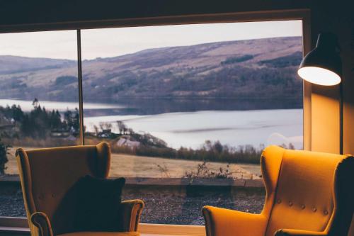 a room with a view of a lake through a window at Boreland Loch Tay in Aberfeldy