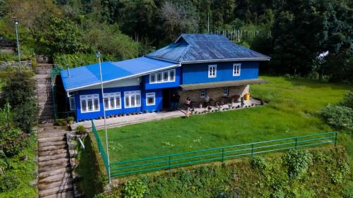 a blue house with a group of dogs in front of it at The Barfung Retreat in Gangtok