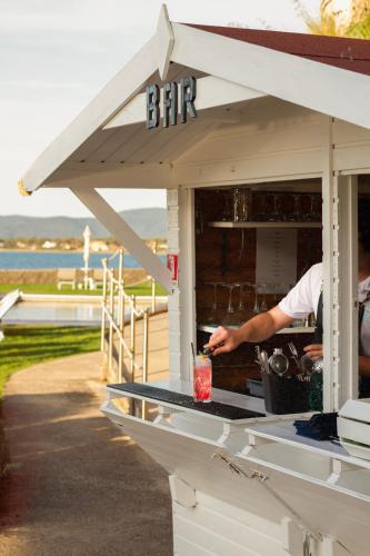 a man is making a drink in a bar at Hotel Villa Domizia in Porto Santo Stefano