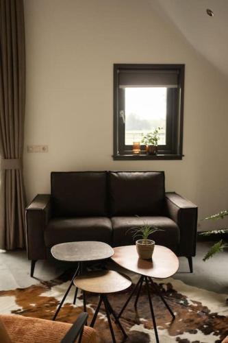 a living room with a couch and two tables at Sfeervolle woning in boerderijstijl in Zelhem