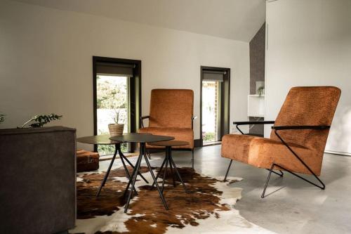 a living room with two chairs and a table at Sfeervolle woning in boerderijstijl in Zelhem