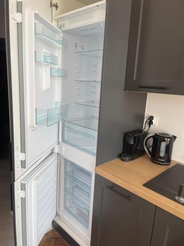a refrigerator with clear glass shelves in a kitchen at Apartamenty Warszawska in Toruń