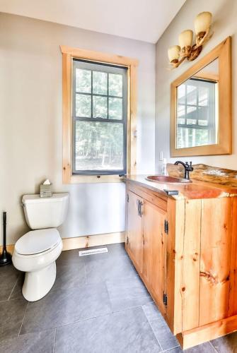a bathroom with a toilet and a sink and a window at Luxurious Home & Amazing Views in Windham
