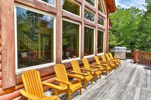 a row of chairs sitting on the deck of a cabin at Luxurious Home & Amazing Views in Windham