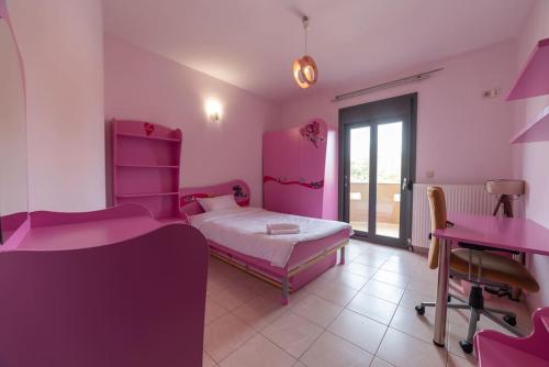 a pink bedroom with a bed and a desk at Vila Serres Gr in Serres