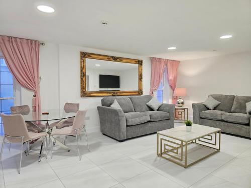 a living room with two couches and a table at Beautiful Cardiff Bay Apartment in Cardiff