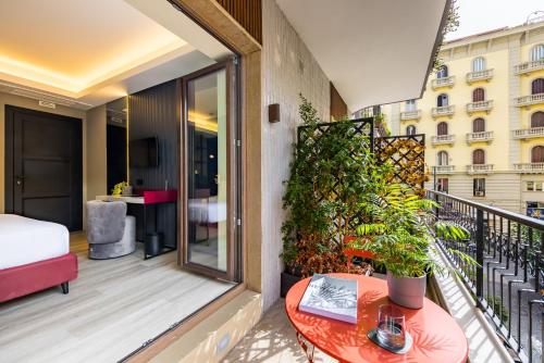 a balcony with a bed and a table at MH SUITES Plebiscito in Naples