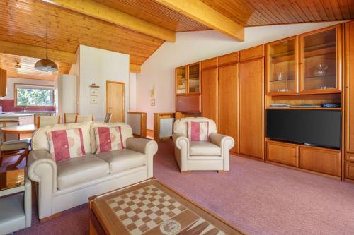 a living room with two chairs and a flat screen tv at The Lodges at Craigendarroch Country Club in Ballater