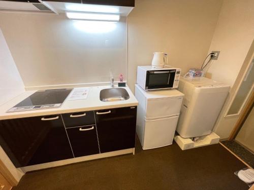 a small kitchen with a sink and a microwave at HIZ HOTEL Gion-Shirakawa in Kyoto