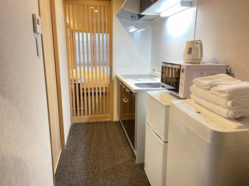 a kitchen with a washer and dryer with a microwave at HIZ HOTEL Gion-Shirakawa in Kyoto