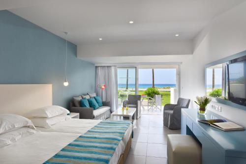 a hotel room with a bed and a living room at Nissi Beach Resort in Ayia Napa