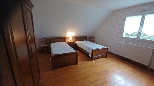 Una pequeña habitación con dos camas y una ventana. en Gite etretat, en Étretat