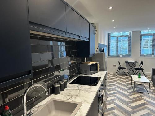 a kitchen with a sink and a counter top at City Centre Apartments - 1 Bed Apartments - 5 Min Walk from Train Station - Designed for Professionals - Free WiFi - Full Kitchen - Sofa Bed - Ideal for Long Work Stays in Peterborough