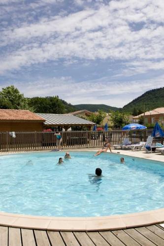un groupe de personnes nageant dans une piscine dans l'établissement Chalet 3 étoiles - ccaaafc, à Sorèze