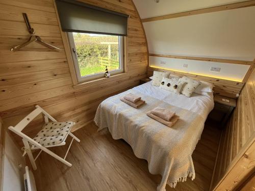 a bedroom with a bed and a window and a chair at Sunnybank by Wigwam Holidays in Reston