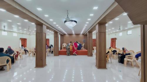 a lobby with people sitting in chairs in a building at Hotel Safra in Chennai