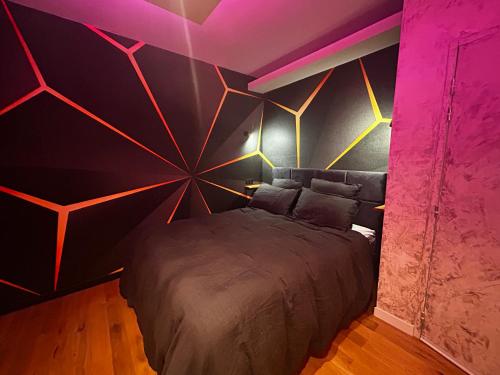 a bedroom with a large bed with a colorful wall at L'instant in Duras