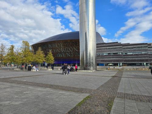 a large building with people walking in front of it at Beautiful Cardiff Bay Apartment in Cardiff