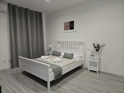 a white bedroom with a white bed and a window at Be Your Home - Guest House Il Ferroviere in Civitavecchia