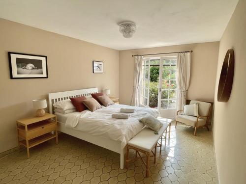 una camera da letto con un letto, una sedia e una finestra di VILLA LA LOUBIANE VI4428 By Riviera Holiday Homes a Vence