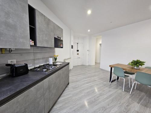a kitchen with a counter and a table and a stove at Be Your Home - Guest House Il Ferroviere in Civitavecchia