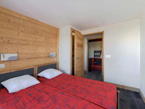 - une chambre avec un lit rouge et deux oreillers blancs dans l'établissement Appartement rénové 8 pers · Piscine · Sauna · Hammam · Animaux OK - FR-1-181-1925, à La Plagne Tarentaise