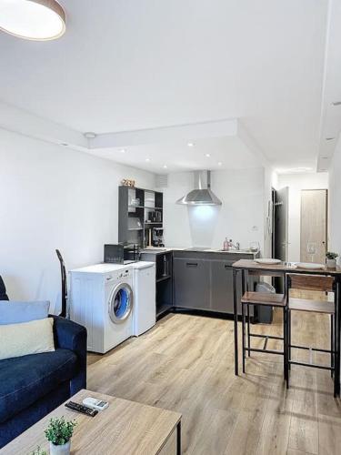 un salon avec un canapé bleu et une cuisine dans l'établissement Studio proche mer - Climatisé, à Cagnes-sur-Mer