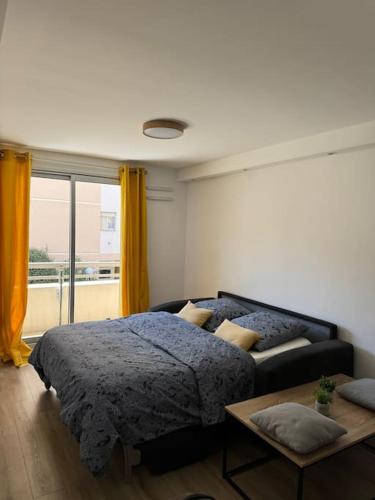 une chambre avec un lit, une table et une fenêtre dans l'établissement Studio proche mer - Climatisé, à Cagnes-sur-Mer