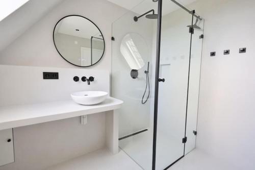 Un baño blanco con lavabo y espejo. en Inselidylle Villa Kunterbunt, en Fehmarn