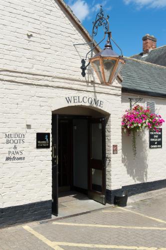 a white brick building with a door and welcome sign at Green Dragon, Welton by Marston's Inns in South Cave