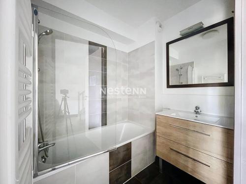 une salle de bain avec une baignoire, un lavabo et un miroir dans l'établissement 3524 - T3 6 pers avec piscine à 4km des plages, à Latour-Bas-Elne