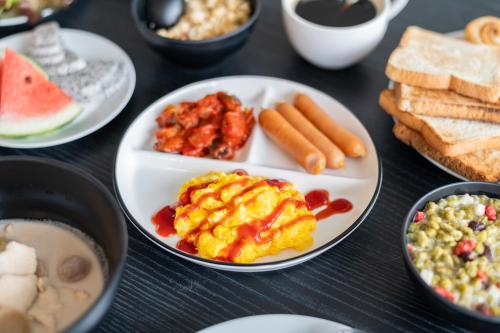 een tafel met daarop borden en kommen met eten bij Kokotel Pattaya North Beach in Noord Pattaya