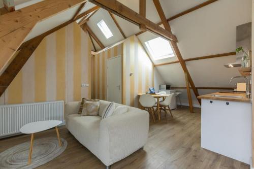 a living room with a white couch and a table at Zuss & Sleep Koudekerke in Koudekerke