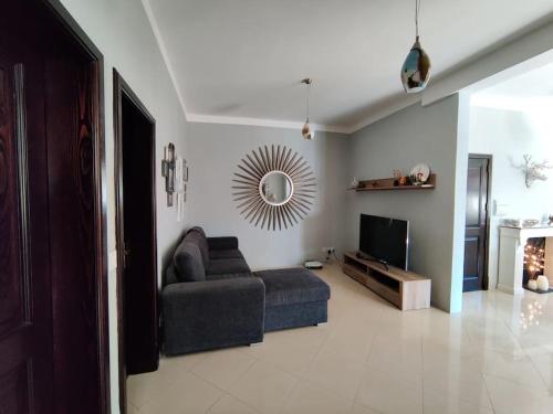 Una sala de estar con un sofá y un televisor. en Peaceful & Modern Corner Apartment, en Qala