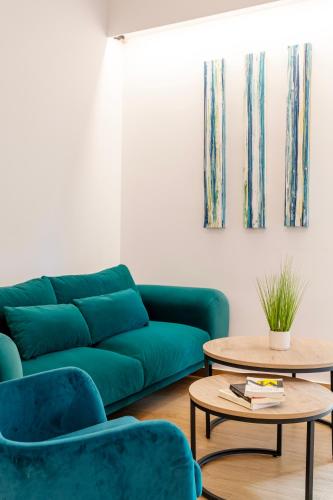 a living room with a green couch and two tables at Lighthouse Kipseli in Athens