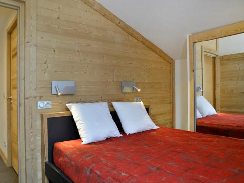 - une chambre avec un lit et un mur en bois dans l'établissement Duplex Rénové 6 Pièces · Accès Skis aux Pieds · Espace Bien-être · Proche Commerces - FR-1-181-2283, à La Plagne Tarentaise