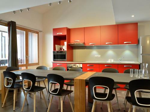 une cuisine avec une grande table et des chaises dans l'établissement Duplex Rénové 6 Pièces · Accès Skis aux Pieds · Espace Bien-être · Proche Commerces - FR-1-181-2283, à La Plagne Tarentaise