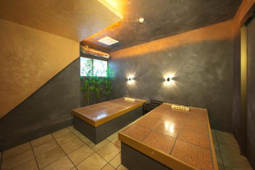 a room with two tables and a window at Meitei no Yado Hotel Koshien in Fuefuki