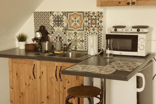 a kitchen with a sink and a microwave at Repülőhal Apartmanház in Zebegény